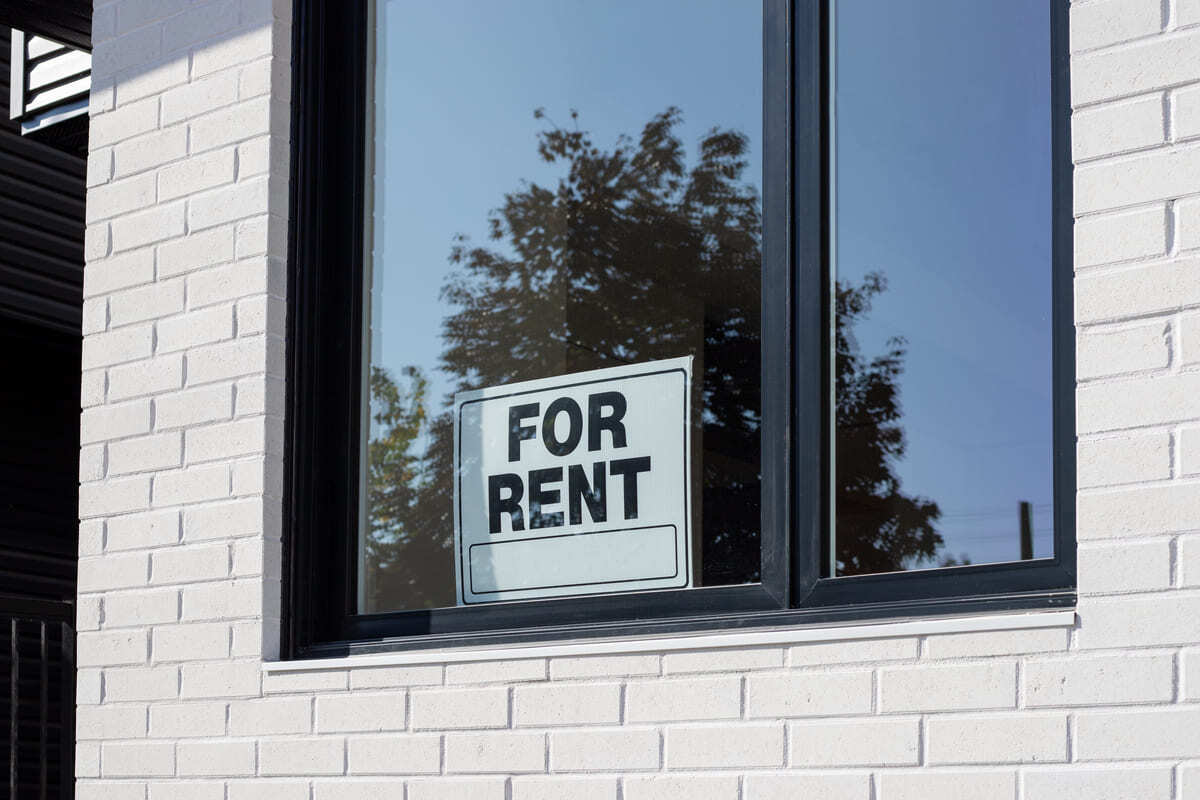 A sign in the window of a rental property that says “for rent.”
