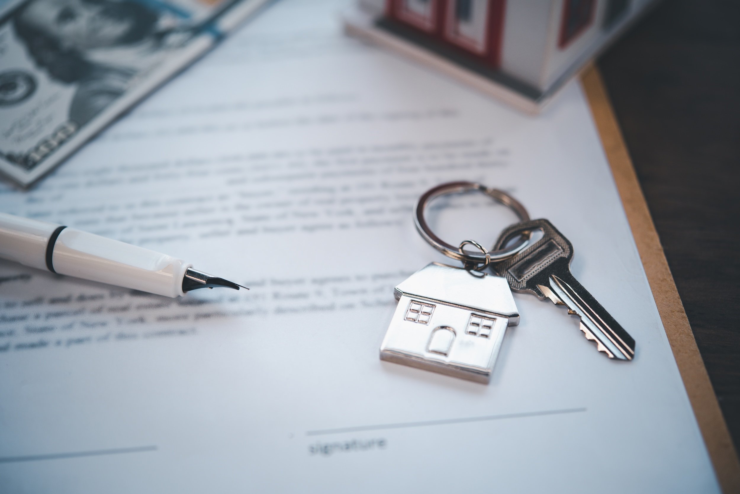 The image features a home key and keychain on a contract to represent a lease in Florida. 