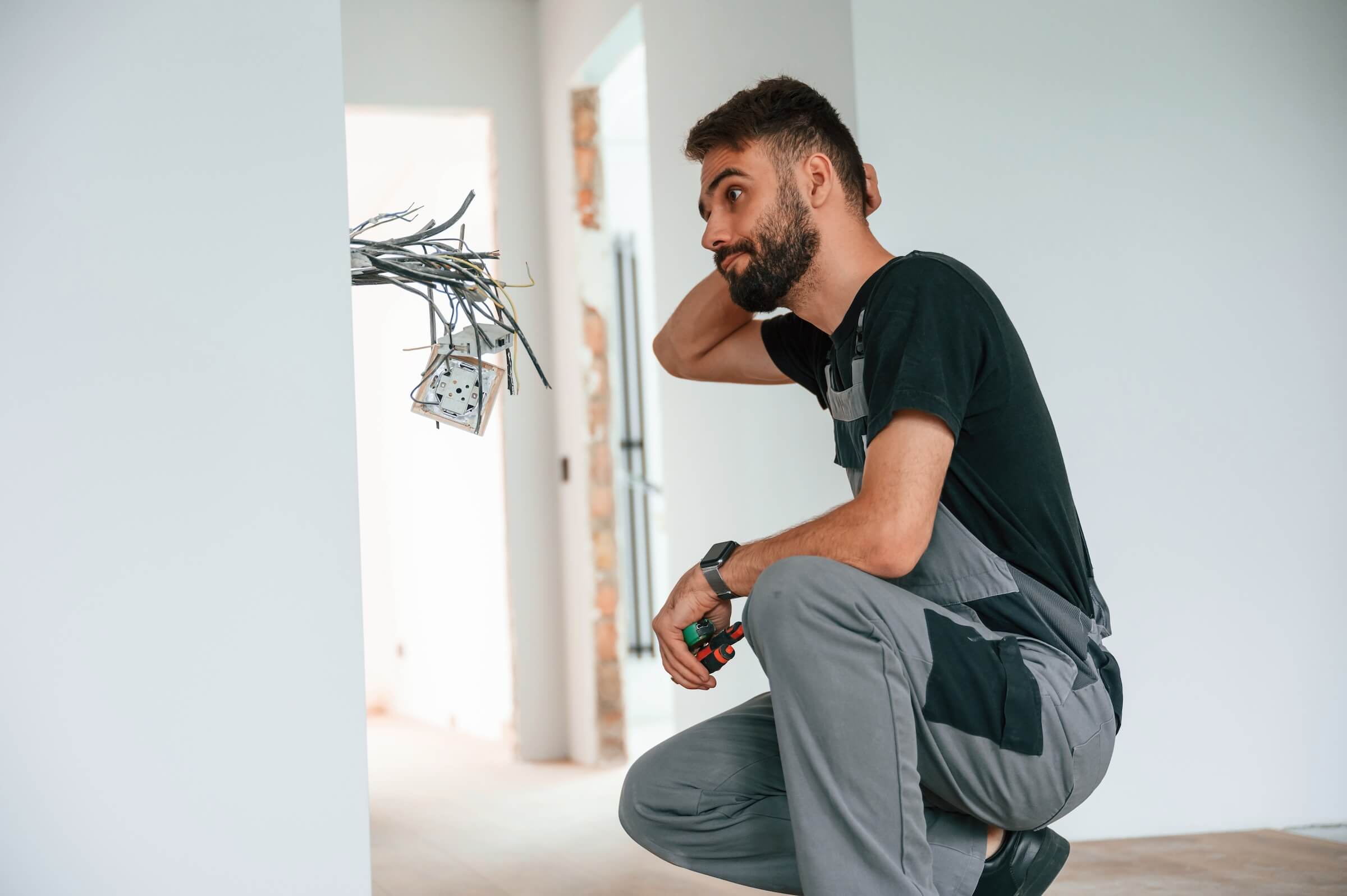 Male rental property owner looking at electrical wiring in Florida rental home
