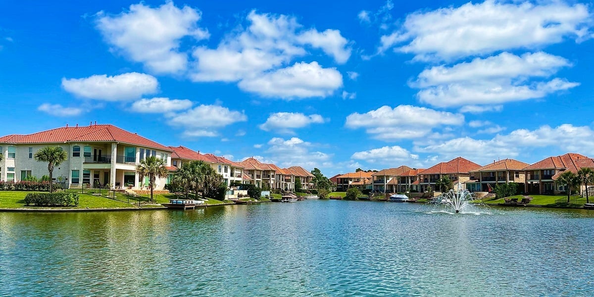 Florida waterfront rental homes surrounding a scenic lake under a bright blue sky