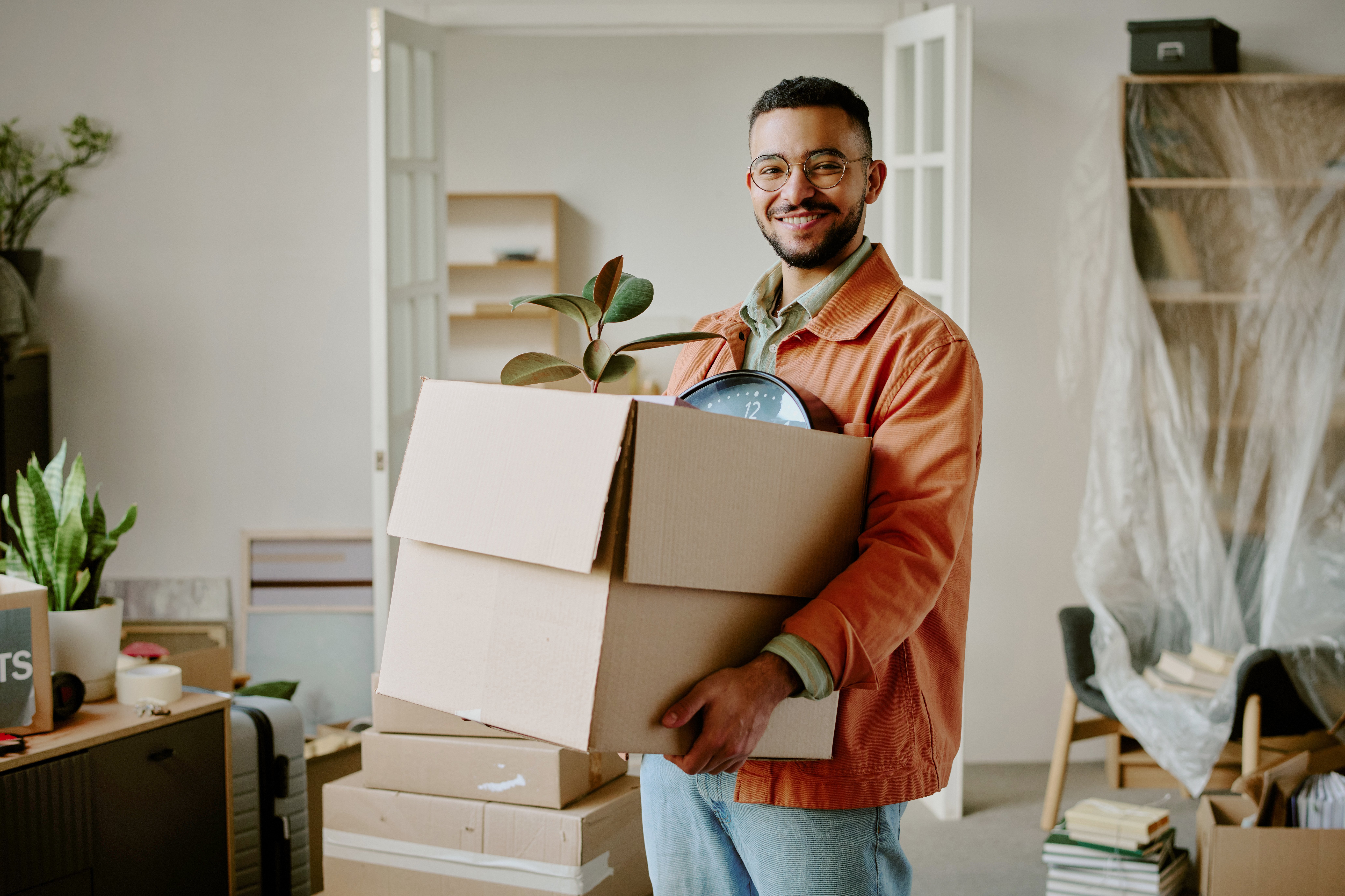 Man holding a box, moving into a new apartment. 